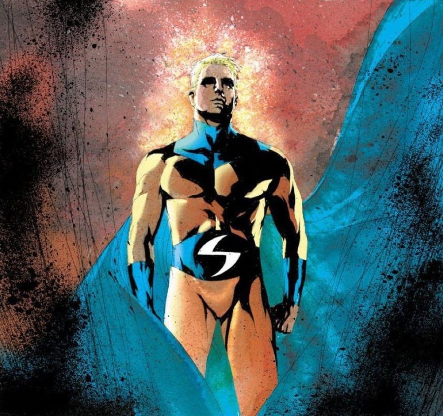 A blond-haired man stands in a golden suit with a white S on his blue belt and a blue cape blowing behind him