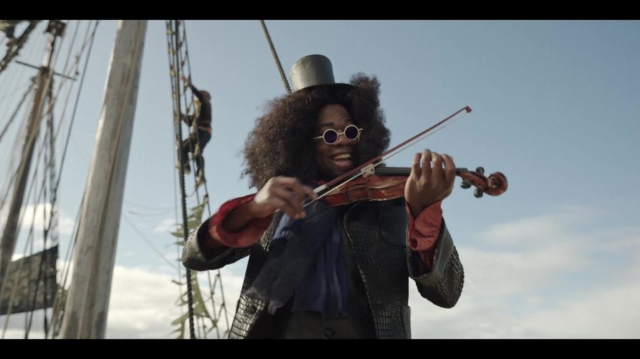 A Black man with an afro plays a violin